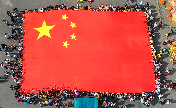 潭瀑峡游人广场上,数千名游客围绕巨幅国旗齐唱《我爱你中国》 孙庆新