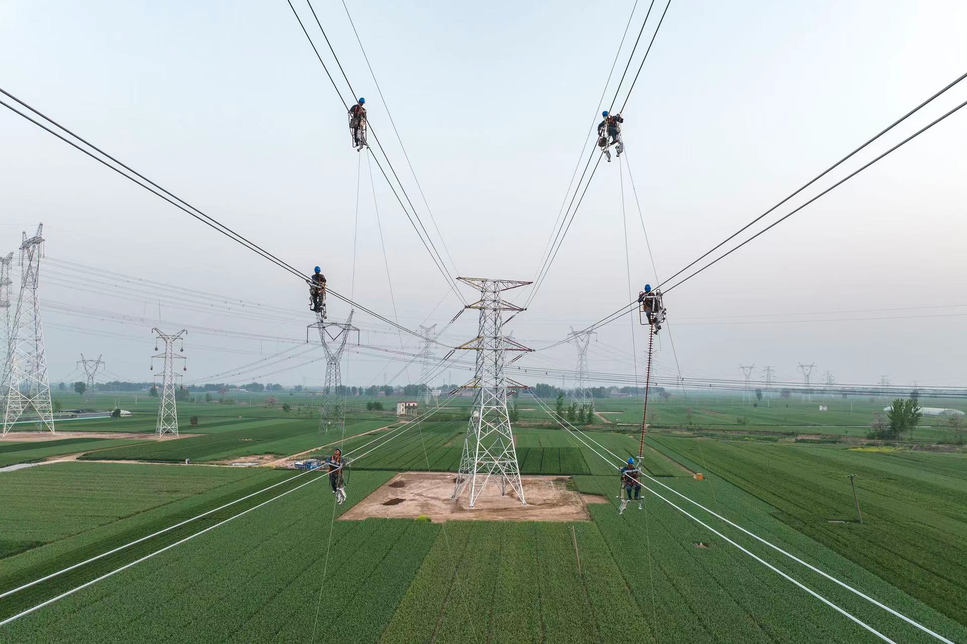 国网河南电力员工高空安装相间间隔棒,全力推进重点工程建设.